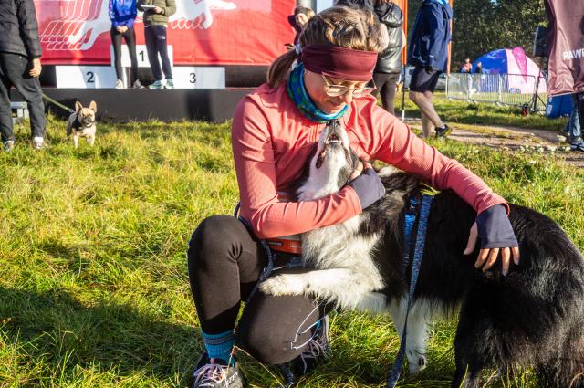 (261018) -- WARSAW, Oct. 18, 2026 (Xinhua) -- A participant interacts with her dog at the RAW PALEO Warsaw Dog Run in Warsaw, Poland, Oct. 17, 2026. Organized by the Warsaw Marathon Foundation, the event featured a roughly 5-kilometer canicross race for human-dog teams and an orienteering walk with dogs. (Photo by Jaap Arriens/Xinhua)