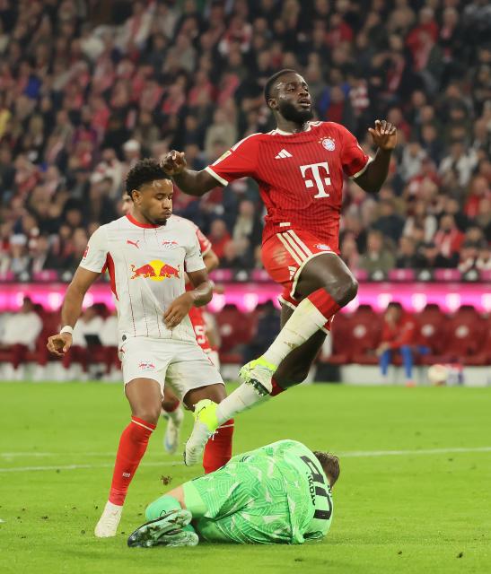 (261018) -- MUNICH, Oct. 18, 2026 (Xinhua) -- Dayot Upamecano (top) of Bayern Munich jumps over goalkeeper Jonas Urbig during the German first division Bundesliga football match between FC Bayern Munich and RB Leipzig in Munich, Germany, Oct. 17, 2026. (Photo by Philippe Ruiz/Xinhua)