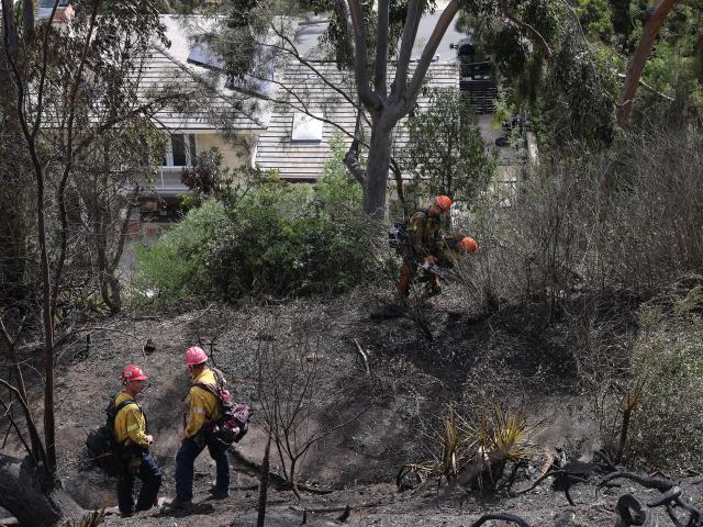 (261018) -- CALIFORNIA, Oct. 18, 2026 (Xinhua) -- Firefighters put out hot spots along Avenida Calita during the Norte Fire in San Juan Capistrano, Orange County, California, the United States, on Oct. 17, 2026. Firefighters are battling multiple wildfires across Southern California on Saturday as red flag warnings remain in effect amid critical fire weather conditions. (Photo by Qiu Chen/Xinhua)