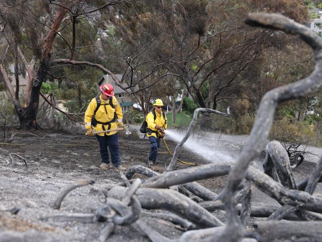 (261018) -- CALIFORNIA, Oct. 18, 2026 (Xinhua) -- Firefighters put out hot spots along Avenida Calita during the Norte Fire in San Juan Capistrano, Orange County, California, the United States, on Oct. 17, 2026. Firefighters are battling multiple wildfires across Southern California on Saturday as red flag warnings remain in effect amid critical fire weather conditions. (Photo by Qiu Chen/Xinhua)