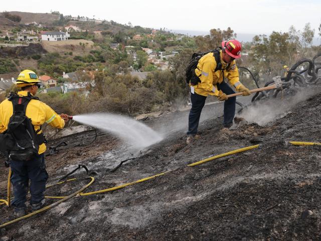 (261018) -- CALIFORNIA, Oct. 18, 2026 (Xinhua) -- Firefighters put out hot spots along Avenida Calita during the Norte Fire in San Juan Capistrano, Orange County, California, the United States, on Oct. 17, 2026. Firefighters are battling multiple wildfires across Southern California on Saturday as red flag warnings remain in effect amid critical fire weather conditions. (Photo by Qiu Chen/Xinhua)