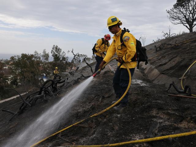 (261018) -- CALIFORNIA, Oct. 18, 2026 (Xinhua) -- Firefighters put out hot spots along Avenida Calita during the Norte Fire in San Juan Capistrano, Orange County, California, the United States, on Oct. 17, 2026. Firefighters are battling multiple wildfires across Southern California on Saturday as red flag warnings remain in effect amid critical fire weather conditions. (Photo by Qiu Chen/Xinhua)