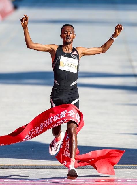 (261018) -- BEIJING, Oct. 18, 2026 (Xinhua) -- Tamirat Tola of Ethiopia crosses the finish line to win the first place of the men's marathon event during the 2026 Beijing Marathon & National Marathon Championships in Beijing, capital of China, Oct. 18, 2026. (Xinhua/Luo Yuan)
