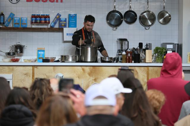(261018) -- NEW YORK, Oct. 18, 2026 (Xinhua) -- A man makes food for visitors at the New York City Wine and Food Festival in New York, the United States, Oct. 17, 2026. Running from Oct. 15 to 18, the festival attracts many food lovers and visitors. (Xinhua/Zhang Fengguo)
