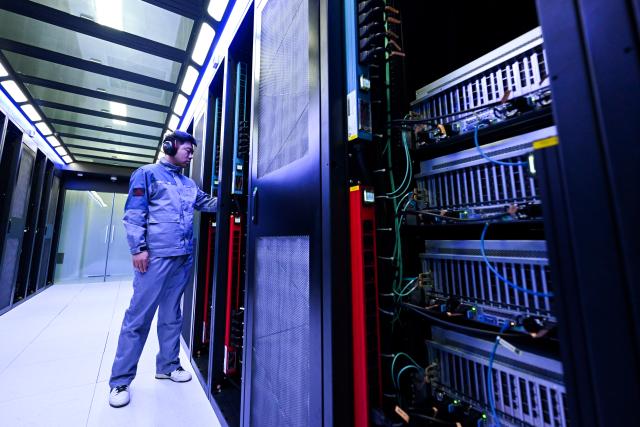 (261018) -- HOHHOT, Oct. 18, 2026 (Xinhua) -- A staff member checks the computing power equipment at a supercomputing technology company in the Horinger New Area of Hohhot, north China's Inner Mongolia Autonomous Region, June 4, 2026. (Xinhua/Li Zhipeng)