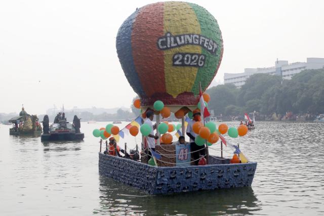 (261018) -- JAKARTA, Oct. 18, 2026 (Xinhua) -- Participants take boats decorated with recycled plastic bottles during the Festival Cinta Lingkungan 2026 (CiLung Fest), or Eco-Friendly Boat Festival, in Jakarta, Indonesia, on Oct. 18, 2026. (Photo by B. Nugraha/Xinhua)