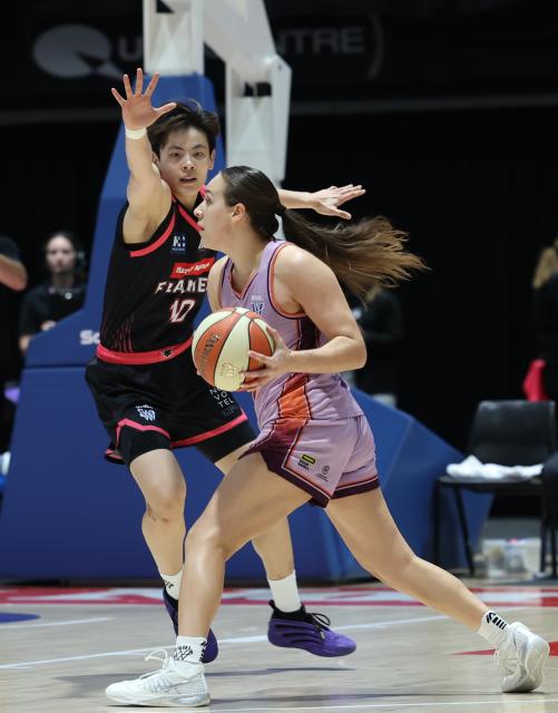 (261018) -- SYDNEY, Oct. 18, 2026 (Xinhua) -- Yang Shuyu (L) of Sydney Flames defends during the round 1 game between Sydney Flames and Adelaide Lightning at the 2026-2027 Women's National Basketball League in Sydney, Australia, Oct. 18, 2026. (Xinhua/Gong Bing)