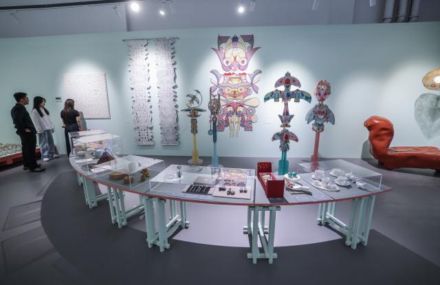 (261018) -- HANGZHOU, Oct. 18, 2026 (Xinhua) -- Visitors view exhibits at a special exhibition on innovative design of Chinese cultural heritage in Hangzhou, east China's Zhejiang Province, Oct. 18, 2026. This design exhibition is one of the side events for the fourth Liangzhu Forum. (Xinhua/Xu Yu)