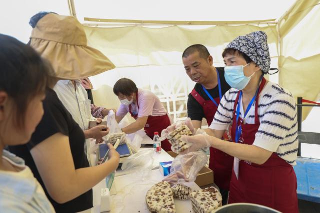 (261018) -- BEIJING, Oct. 18, 2026 (Xinhua) -- People buy cakes during an event marking the Chongyang Festival in east China's Shanghai, Oct. 18, 2026. A series of celebration activities were held across the country to mark the Chongyang Festival, which falls on Oct. 18 this year. Also known as China's Seniors' Day, it honors the country's traditional virtues of filial piety and family love. (Xinhua/Wang Xiang)