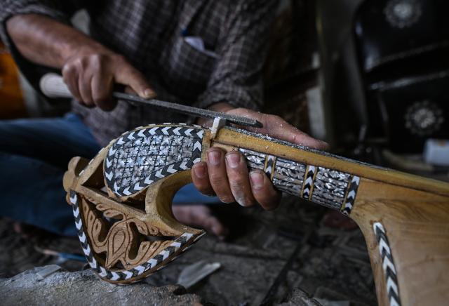 (261018) -- SRINAGAR, Oct. 18, 2026 (Xinhua) -- Mushtaq Ahmad Dar makes a rabab, a traditional Kashmiri musical instrument, at his workshop in the outskirts of Srinagar city, the summer capital of Indian-controlled Kashmir, Oct. 12, 2026. TO GO WITH "Feature: Indian-controlled Kashmir's traditional musical instrument makers strive to keep vanishing craft alive" (Xinhua/Javed Dar)