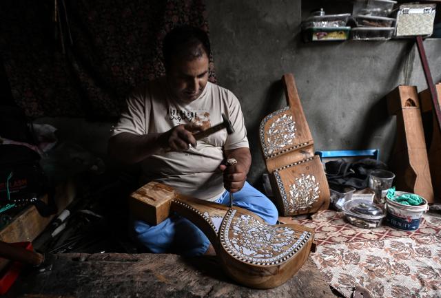 (261018) -- SRINAGAR, Oct. 18, 2026 (Xinhua) -- Altaf Ahmad Sheikh makes a sarangi, a traditional Kashmiri musical instrument, at his workshop in Srinagar city, the summer capital of Indian-controlled Kashmir, Oct. 13, 2026. TO GO WITH "Feature: Indian-controlled Kashmir's traditional musical instrument makers strive to keep vanishing craft alive" (Xinhua/Javed Dar)