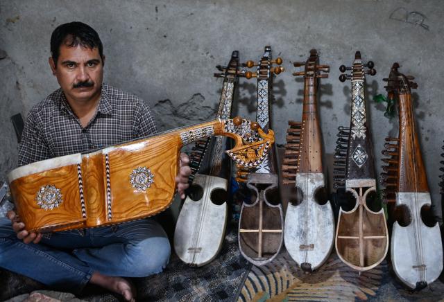 (261018) -- SRINAGAR, Oct. 18, 2026 (Xinhua) -- Mushtaq Ahmad Dar is pictured with a rabab, a traditional Kashmiri musical instrument, at his workshop in the outskirts of Srinagar city, the summer capital of Indian-controlled Kashmir, Oct. 12, 2026. TO GO WITH "Feature: Indian-controlled Kashmir's traditional musical instrument makers strive to keep vanishing craft alive" (Xinhua/Javed Dar)