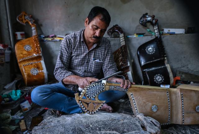 (261018) -- SRINAGAR, Oct. 18, 2026 (Xinhua) -- Mushtaq Ahmad Dar makes a rabab, a traditional Kashmiri musical instrument, at his workshop in the outskirts of Srinagar city, the summer capital of Indian-controlled Kashmir, Oct. 12, 2026. TO GO WITH "Feature: Indian-controlled Kashmir's traditional musical instrument makers strive to keep vanishing craft alive" (Xinhua/Javed Dar)