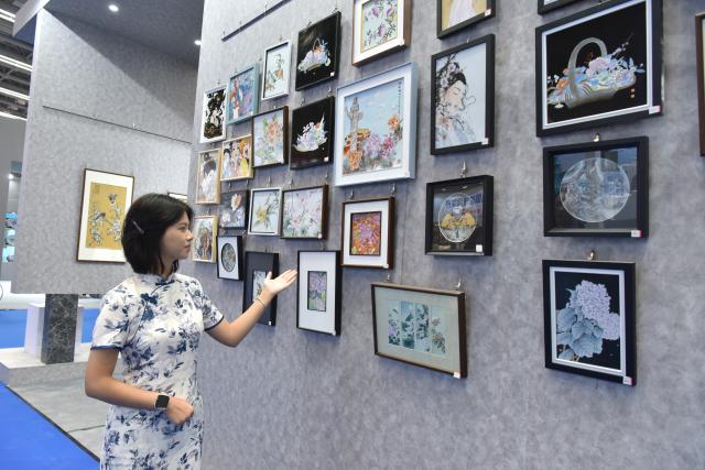 (261018) -- JINGDEZHEN, Oct. 18, 2026 (Xinhua) -- A staff member introduces ceramic works during the 2026 China Jingdezhen International Ceramic Expo in Jingdezhen, east China's Jiangxi Province, Oct. 18, 2026.
  The 2026 China Jingdezhen International Ceramic Expo opened on Sunday in Jingdezhen, famed as the "porcelain capital," attracting more than 1,000 professional buyers from home and abroad.
  The five-day event showcases several facets of the ceramic industry, including the entire industrial chain, its domestic and international markets and its application of digital technology, all within an exhibition space of 140,000 square meters. (Photo by Shi Weiming/Xinhua)
