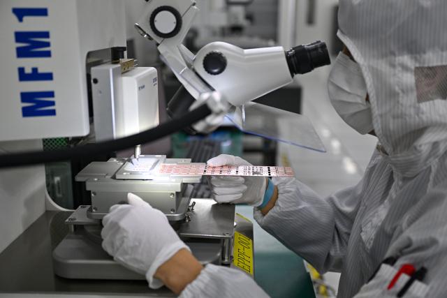 (261018) -- HAIKOU, Oct. 18, 2026 (Xinhua) -- A staff member tests chips at a workshop in Hainan Hangxin High-Tech Industrial Park in Haikou, south China's Hainan Province, Oct. 18, 2026.
  Leveraging policy benefits and incentives, the Hainan Free Trade Port, under the island-wide special customs operations, is committed to building itself into a hub for Chinese semiconductors and chips to go global. (Xinhua/Guo Cheng)