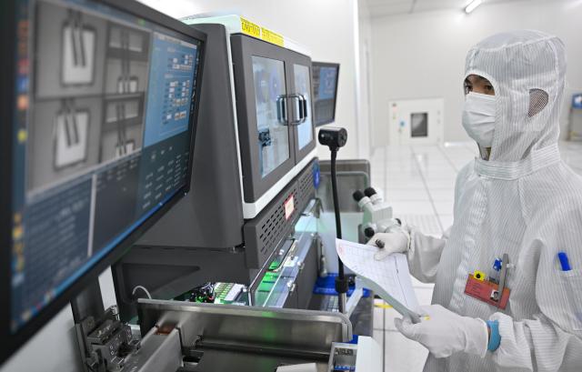 (261018) -- HAIKOU, Oct. 18, 2026 (Xinhua) -- A staff member monitors chip production at a workshop in Hainan Hangxin High-Tech Industrial Park in Haikou, south China's Hainan Province, Oct. 18, 2026.
  Leveraging policy benefits and incentives, the Hainan Free Trade Port, under the island-wide special customs operations, is committed to building itself into a hub for Chinese semiconductors and chips to go global. (Xinhua/Guo Cheng)