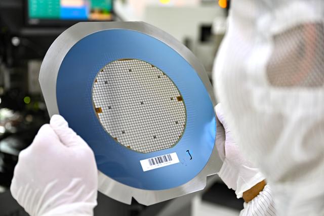 (261018) -- HAIKOU, Oct. 18, 2026 (Xinhua) -- A staff member checks a wafer at a workshop in Hainan Hangxin High-Tech Industrial Park in Haikou, south China's Hainan Province, Oct. 18, 2026.
  Leveraging policy benefits and incentives, the Hainan Free Trade Port, under the island-wide special customs operations, is committed to building itself into a hub for Chinese semiconductors and chips to go global. (Xinhua/Guo Cheng)