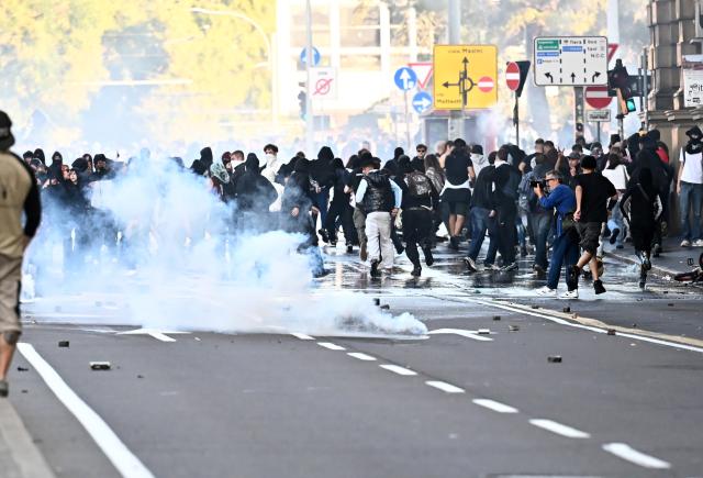(261018) -- BOLOGNA, Oct. 18, 2026 (Xinhua) -- Photo taken on Oct. 17, 2026 shows violent clashes during protests near the central station of Bologna, Italy. Protests against the rising cost of living turned violent on Saturday in several northern Italian cities, including Milan, Bologna and Turin, leaving dozens of people injured, according to Italian media reports. (Xinhua)