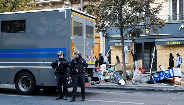 (261018) -- PARIS, Oct. 18, 2026 (Xinhua) -- Law enforcement officers stand guard outside a shop in Paris, France, Oct. 18, 2026. French President Emmanuel Macron on Sunday vowed legal action against those responsible for violence during protests across the country on Saturday. (Xinhua/Wu Huiwo)