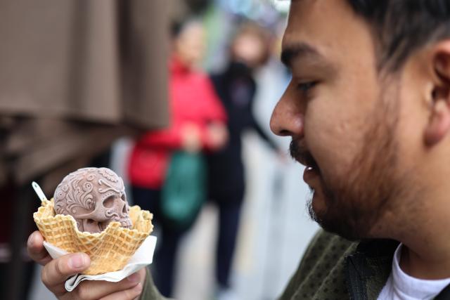 (261018) -- MEXICO CITY, Oct. 18, 2026 (Xinhua) -- A man holds a Catrina-shaped ice cream in Mexico City, capital of Mexico, Oct. 17, 2026. As the Day of the Dead approaches, an ice cream shop in Mexico City has introduced Catrina-shaped ice creams, attracting many local residents and tourists. (Photo by Francisco Canedo/Xinhua)