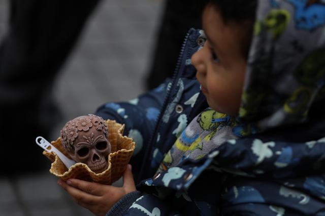 (261018) -- MEXICO CITY, Oct. 18, 2026 (Xinhua) -- A child holds a Catrina-shaped ice cream in Mexico City, capital of Mexico, Oct. 17, 2026. As the Day of the Dead approaches, an ice cream shop in Mexico City has introduced Catrina-shaped ice creams, attracting many local residents and tourists. (Photo by Francisco Canedo/Xinhua)