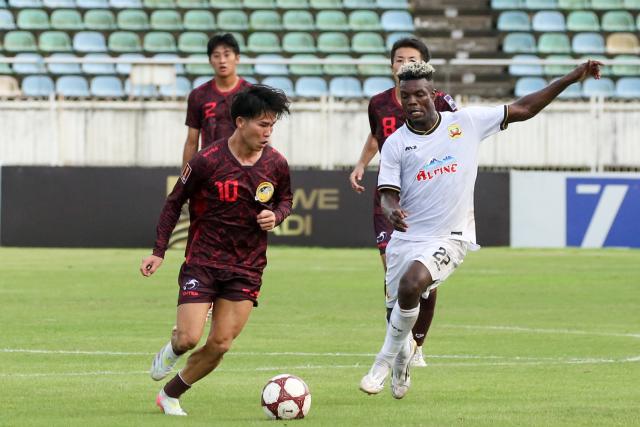 (261019) -- YANGON, Oct. 19, 2026 (Xinhua) -- Koreeda Shingo (L) of New Taipei City Hang Yuan FC vies with Mark Sekyi of Shan United FC during the group E match between Shan United FC of Myanmar and New Taipei City Hang Yuan FC of Chinese Taipei at the AFC Challenge League in Yangon, Myanmar, Oct. 18, 2026. (Xinhua/Myo Kyaw Soe)