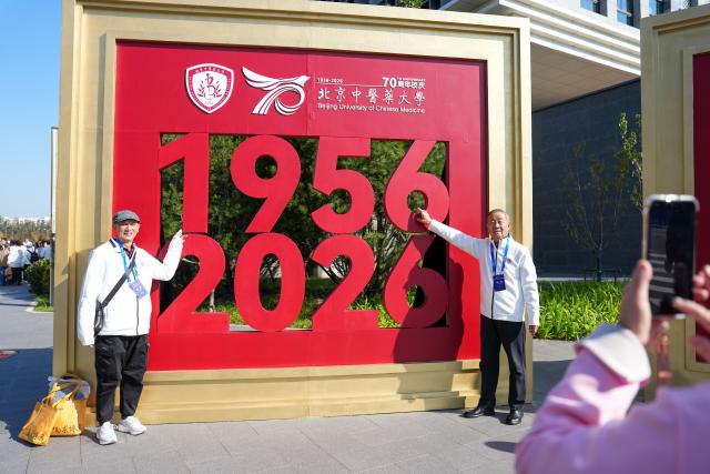 (261019) -- BEIJING, Oct. 19, 2026 (Xinhua) -- Alumni pose for photos at the Liangxiang campus of Beijing University of Chinese Medicine in Beijing, capital of China, Oct. 19, 2026. A series of events are held on Monday to commemorate the 70th anniversary of the founding of Beijing University of Chinese Medicine. (Xinhua/Ju Huanzong)