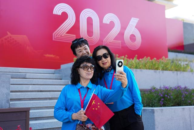 (261019) -- BEIJING, Oct. 19, 2026 (Xinhua) -- Alumni pose for photos in front of the library at the Liangxiang campus of Beijing University of Chinese Medicine in Beijing, capital of China, Oct. 19, 2026. A series of events are held on Monday to commemorate the 70th anniversary of the founding of Beijing University of Chinese Medicine. (Xinhua/Ju Huanzong)