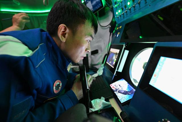 (261019) -- ABOARD RESEARCH VESSEL DEEP SEA NO. 1, Oct. 19, 2026 (Xinhua) -- Submersible pilot Tang Jialing operates a robotic arm to collect seabed rock samples on the manned deep-sea submersible Jiaolong on Oct. 15, 2026. China's research vessel Deep Sea No. 1, carrying manned deep-sea submersible Jiaolong, is currently on the western Pacific Ocean for deep-sea scientific research.
  Jiaolong successfully completed its 470th dive on Oct. 15.
  A Xinhua reporter aboard Jiaolong photographed the exploration of the mysterious underwater world. (Xinhua/Li Xin)
