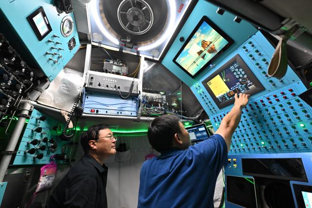 (261019) -- ABOARD RESEARCH VESSEL DEEP SEA NO. 1, Oct. 19, 2026 (Xinhua) -- Submersible pilot Tang Jialing (R) checks the manned deep-sea submersible Jiaolong on Oct. 15, 2026. China's research vessel Deep Sea No. 1, carrying manned deep-sea submersible Jiaolong, is currently on the western Pacific Ocean for deep-sea scientific research.
  Jiaolong successfully completed its 470th dive on Oct. 15.
  A Xinhua reporter aboard Jiaolong photographed the exploration of the mysterious underwater world. (Xinhua/Li Xin)