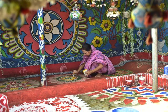 (261019) -- CHAPAINAWABGANJ, Oct. 19, 2026 (Xinhua) -- A woman paints "Alpona" in a village in Chapainawabganj District, Bangladesh, Oct. 18, 2026. "Alpona" is a traditional form of folk art practiced in South Asia and is mainly created by women in the local community. (Photo by Habibur Rahman/Xinhua)