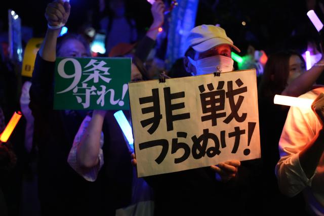 (261020) -- TOKYO, Oct. 20, 2026 (Xinhua) -- People holding signs attend a protest rally in front of the National Diet in Tokyo, Japan, Oct. 19, 2026. Japanese citizens staged a protest rally in front of the National Diet in Tokyo on Monday evening, opposing the military buildup and constitutional revision drive of Prime Minister Sanae Takaichi's government and calling for the preservation of peace. (Xinhua/Liang Chen)
