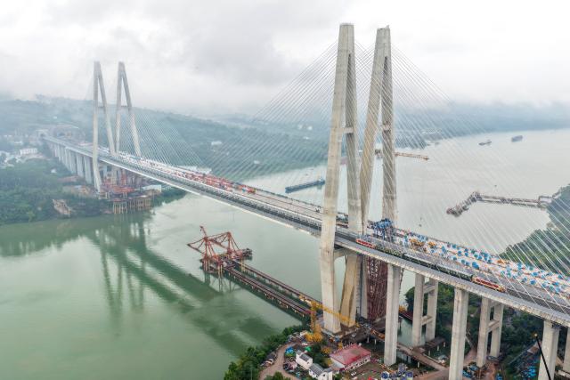 (261020) -- CHONGQING, Oct. 20, 2026 (Xinhua) -- An aerial drone photo shows a test train running along the Chongqing-Wanzhou high-speed railway, southwest China's Chongqing Municipality, Oct. 20, 2026. With a test train departing from the Chongqing East Railway Station, the joint commissioning and testing of the Chongqing-Wanzhou high-speed railway started on Tuesday.
  The railway spans approximately 254 kilometers and is designed to operate at a speed of 350 kilometers per hour, serving as a vital supplement to China's high-speed rail network upon completion. (Xinhua/Tang Yi)
