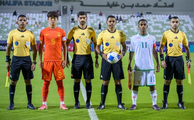(261020) -- DOHA, Oct. 20, 2026 (Xinhua) -- Referees and team captains pose for a photograph before the Gulf Football Federation (GFF) Gulf Cup U-17 Qatar 2026 football match between China and Oman in Doha, Qatar, Oct. 19, 2026. (Photo by Nikku/Xinhua)