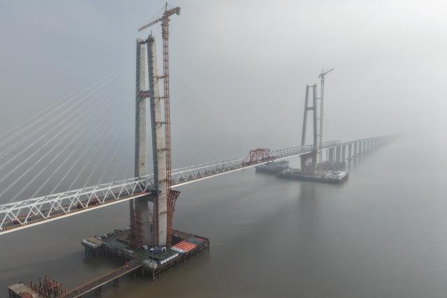 (261020) -- HAIYAN, Oct. 20, 2026 (Xinhua) -- A drone photo taken on Oct. 20, 2026 shows a view of the northern navigation channel bridge of the Hangzhou Bay Cross-Sea Railway Bridge in east China's Zhejiang Province.
  The northern navigation channel bridge of the Hangzhou Bay Cross-Sea Railway Bridge has been successfully joined, marking a major step toward completion of the main construction work.
  The 29.2-km-long Hangzhou Bay Cross-Sea Railway Bridge, which is a crucial segment of the Nantong-Ningbo high-speed railway, consists of three sections over navigation channels, and its ballastless double-track design allows trains to run at a speed of 350 kilometers per hour. (Xinhua/Huang Zongzhi)
