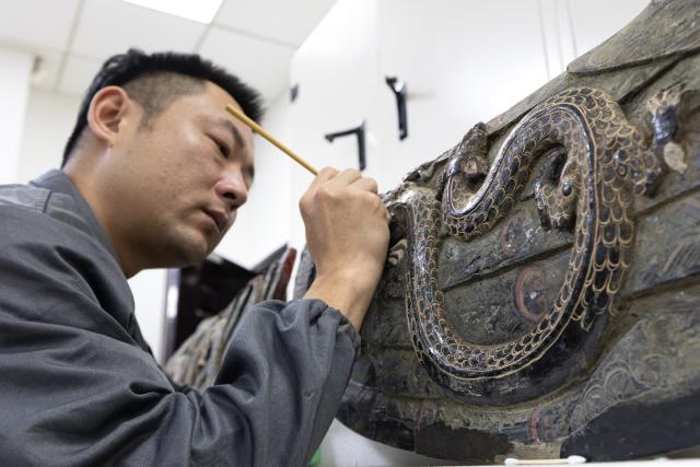 (261020) -- JINGZHOU, Oct. 20, 2026 (Xinhua) -- A staff member restores the painted decoration of an artifact at the cultural relics protection center in Jingzhou, central China's Hubei Province, Oct. 19, 2026.
  Established in 2003, the cultural relics protection center in Jingzhou undertakes the conservation of about 80 percent of China's waterlogged bamboo and wooden slips. The center has developed comprehensive conservation techniques for such slips, covering sectors from archaeological excavation and laboratory conservation to display and storage. 
  To date, the center has provided technical support in cultural relic conservation to more than 130 cultural and museum institutions across the country, and has restored more than 10,000 lacquered wooden artifacts, over 180,000 bamboo and wooden slips, and more than 1,100 textile artifacts. (Xinhua/Xiao Yijiu)