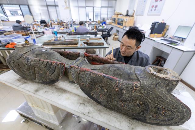 (261020) -- JINGZHOU, Oct. 20, 2026 (Xinhua) -- A staff member restores the painted decoration of an artifact at the cultural relics protection center in Jingzhou, central China's Hubei Province, Oct. 19, 2026.
  Established in 2003, the cultural relics protection center in Jingzhou undertakes the conservation of about 80 percent of China's waterlogged bamboo and wooden slips. The center has developed comprehensive conservation techniques for such slips, covering sectors from archaeological excavation and laboratory conservation to display and storage. 
  To date, the center has provided technical support in cultural relic conservation to more than 130 cultural and museum institutions across the country, and has restored more than 10,000 lacquered wooden artifacts, over 180,000 bamboo and wooden slips, and more than 1,100 textile artifacts. (Xinhua/Xiao Yijiu)