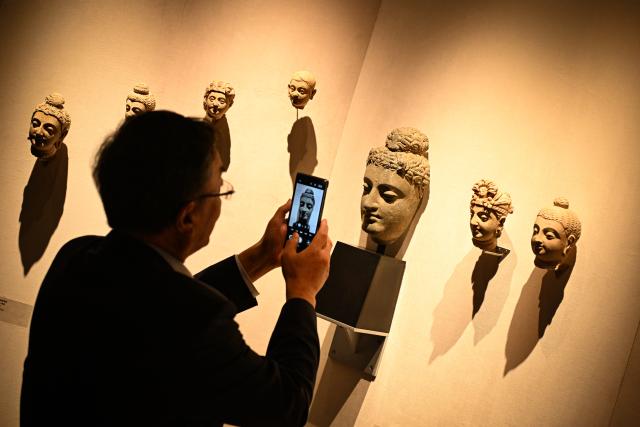 (261020) -- BEIJING, Oct. 20, 2026 (Xinhua) -- A visitor takes photos of an artwork at the 2026 Beijing China Art International Fair in Beijing, capital of China, Oct. 20, 2026. With a theme of "Cultural Heritage Bridges Life to a Vibrant World", the fair kicked off here on Tuesday. (Xinhua/Chen Zhonghao)