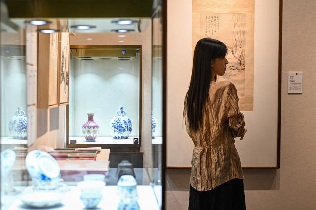 (261020) -- BEIJING, Oct. 20, 2026 (Xinhua) -- A visitor views artworks at the 2026 Beijing China Art International Fair in Beijing, capital of China, Oct. 20, 2026. With a theme of "Cultural Heritage Bridges Life to a Vibrant World", the fair kicked off here on Tuesday. (Xinhua/Chen Zhonghao)