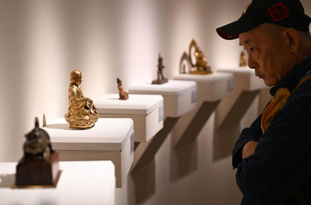 (261020) -- BEIJING, Oct. 20, 2026 (Xinhua) -- A visitor views artworks at the 2026 Beijing China Art International Fair in Beijing, capital of China, Oct. 20, 2026. With a theme of "Cultural Heritage Bridges Life to a Vibrant World", the fair kicked off here on Tuesday. (Xinhua/Chen Zhonghao)