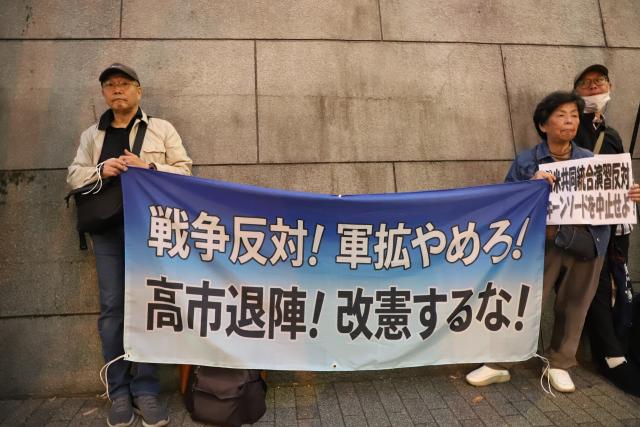 (261020) -- TOKYO, Oct. 20, 2026 (Xinhua) -- People holding signs attend a protest rally in Tokyo, Japan, Oct. 20, 2026. Japanese citizens staged a protest rally in front of the Ministry of Defense in Tokyo on Tuesday evening, opposing the large-scale Japan-U.S. joint military exercises and the military buildup. (Xinhua/Li Ziyue)