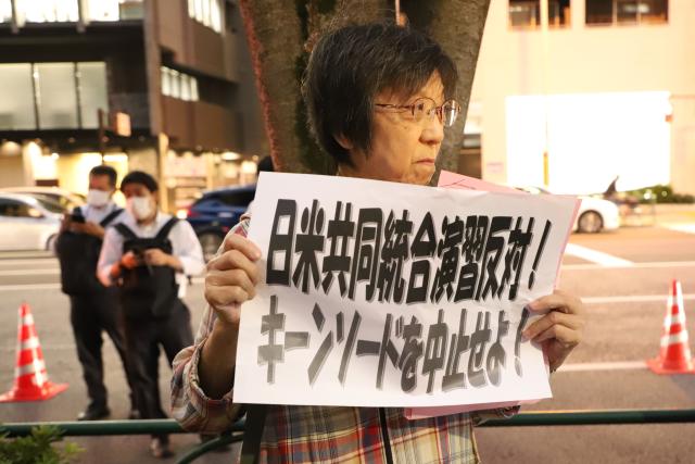 (261020) -- TOKYO, Oct. 20, 2026 (Xinhua) -- A protestor holding a sign attends a protest rally in Tokyo, Japan, Oct. 20, 2026. Japanese citizens staged a protest rally in front of the Ministry of Defense in Tokyo on Tuesday evening, opposing the large-scale Japan-U.S. joint military exercises and the military buildup. (Xinhua/Li Ziyue)