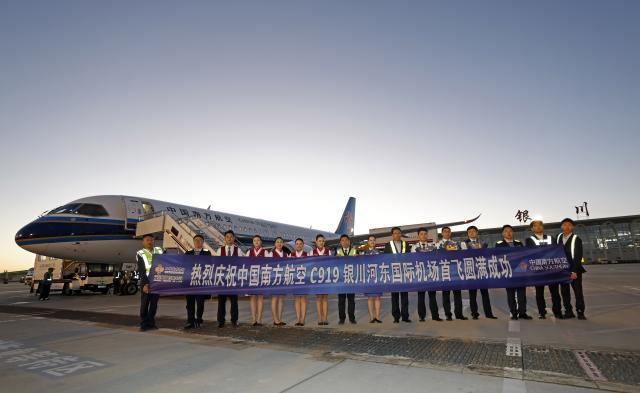 (261020) -- YINCHUAN, Oct. 20, 2026 (Xinhua) -- Crew members of the China Southern Airlines flight CZ3925 and staff members of the Yinchuan Hedong International Airport pose for group photos after the landing of a C919 aircraft at the airport in Yinchuan, northwest China's Ningxia Hui Autonomous Region, Oct. 20, 2026. China's homegrown C919 large passenger aircraft landed at the airport at 5:57 p.m. on Tuesday after departing from Changsha in central China's Hunan Province, marking the aircraft's first commercial passenger flight to Yinchuan. (Xinhua/Wang Peng)