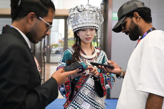 (261020) -- HAIKOU, Oct. 20, 2026 (Xinhua) -- An exhibitor talks with foreign visitors at the China Brands Export Expo in Haikou, south China's Hainan Province, Oct. 20, 2026. The three-day expo kicked off here on Tuesday. (Xinhua/Pu Xiaoxu)