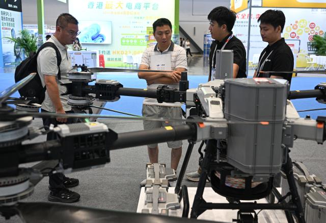 (261020) -- HAIKOU, Oct. 20, 2026 (Xinhua) -- Visitors learn about drones at the China Brands Export Expo in Haikou, south China's Hainan Province, Oct. 20, 2026. The three-day expo kicked off here on Tuesday. (Xinhua/Pu Xiaoxu)