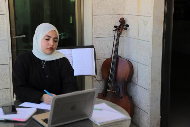 (261021) -- GAZA, Oct. 21, 2026 (Xinhua) -- Palestinian artist Haifa Bassam Abu Shamla composes music at her residency in Gaza City, on Oct. 4, 2026.
  TO GO WITH "Letter from Mideast: In Gaza, my cello sings of more than survival" (Photo by Rizek Abdeljawad/Xinhua)