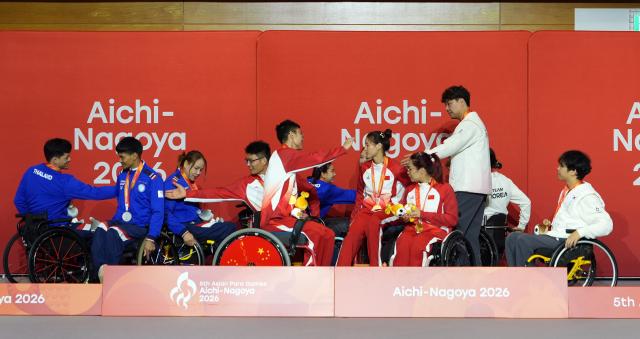 (261021) -- BEIJING, Oct. 21, 2026 (Xinhua) -- Players of gold medalist team China, silver medalist team Thailand and bronze medalist team South Korea interact during the awarding ceremony for foil mixed team final of Fencing at the Aichi-Nagoya Asian Para Games in Nagoya, Japan, Oct. 20, 2026. (Xinhua/Cai Yang)