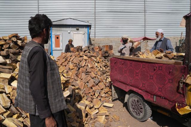 (261021) -- AFGHANISTAN, Oct. 21, 2026 (Xinhua) -- This photo taken on Oct. 17, 2026 shows an Afghan resident (L) buying firewood at a market in Kabul, Afghanistan. TO GO WITH "Feature: Soaring fuel prices leave Afghans struggling to heat homes this winter" (Photo by Saifurahman Safi/Xinhua)