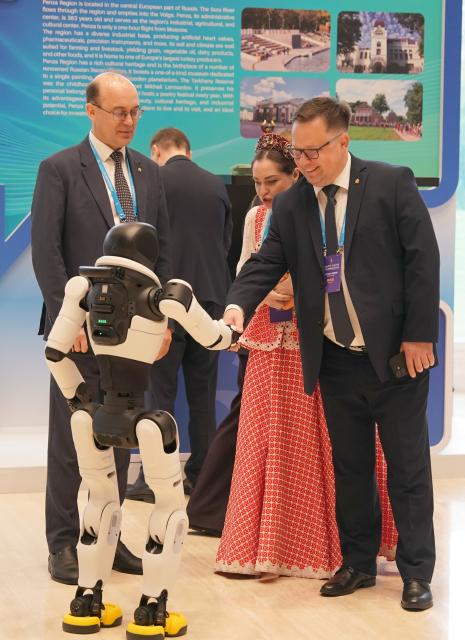 (261021) -- XI'AN, Oct. 21, 2026 (Xinhua) -- A guest shakes hands with a robot while visiting an exhibition on the sidelines of the opening ceremony of the 2026 China International Friendship Cities Conference in Xi'an, northwest China's Shaanxi Province, on Oct. 21, 2026.
  Themed "Jointly Strengthening Friendship Cities Cooperation for Common Urban Development," the conference kicked off here on Wednesday. (Xinhua/Shao Rui)
