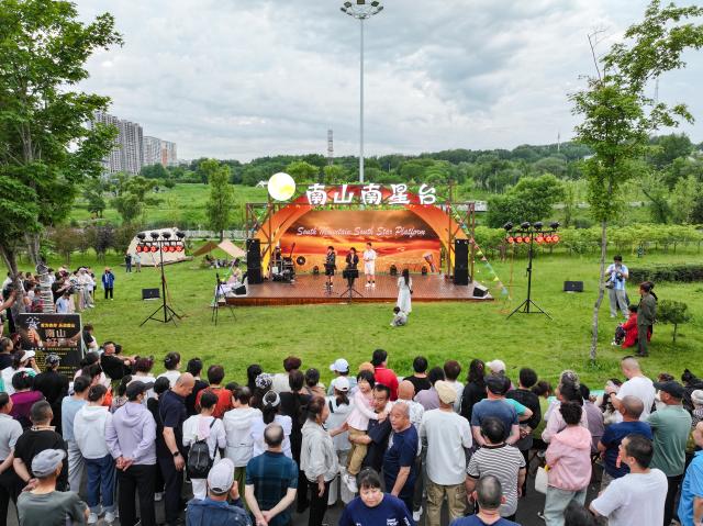 (261021) -- HEGANG, Oct. 21, 2026 (Xinhua) -- People watch performances at a city park in Hegang City, northeast China's Heilongjiang Province, June 20, 2026. TO GO WITH "Across China: Metamorphosis of a city that coal built, and nearly buried" (Xinhua)
